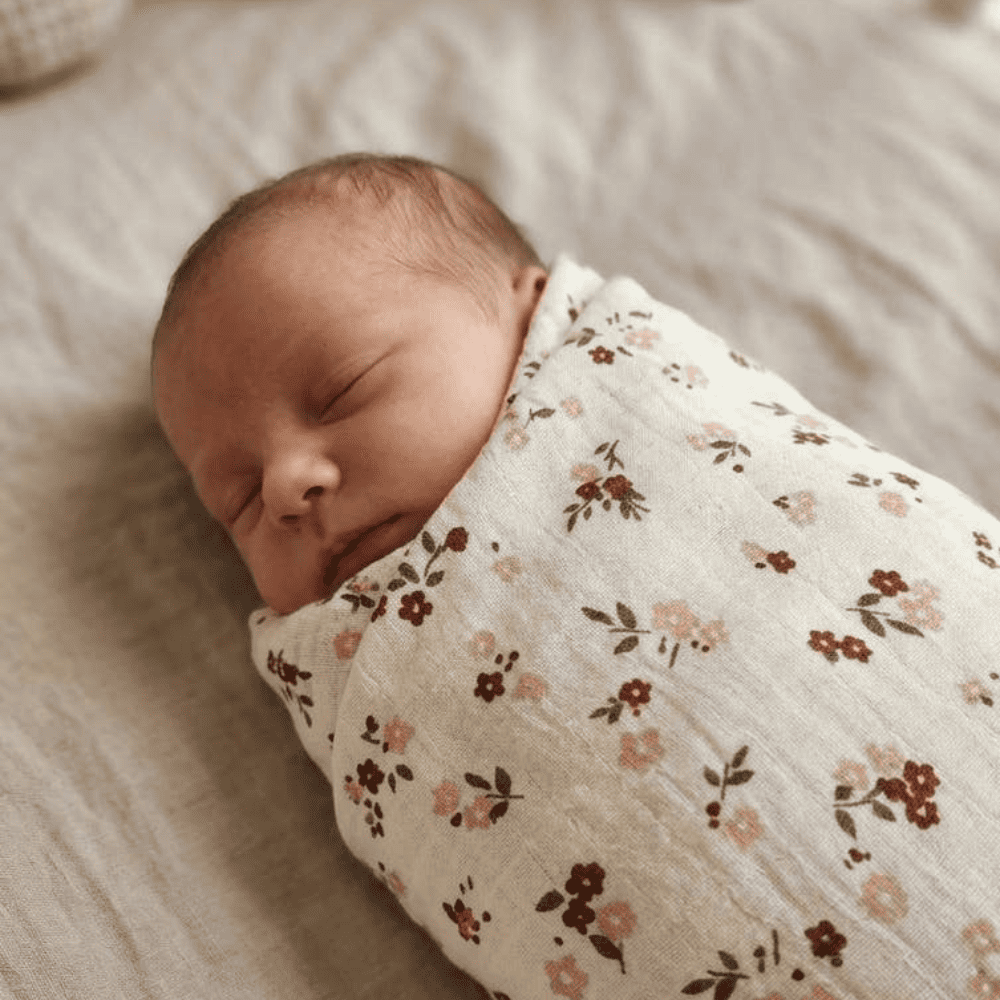 Bébé emmailloté dans un maxi lange en gaze de coton à motif fleuri Lilou – Petite Citrouille