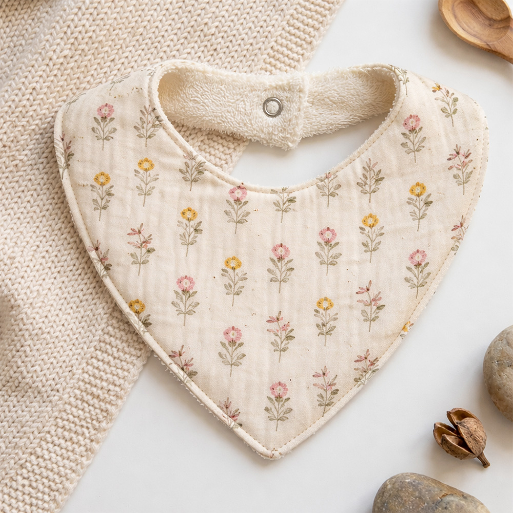 Bavoir beige avec motif de fleurs