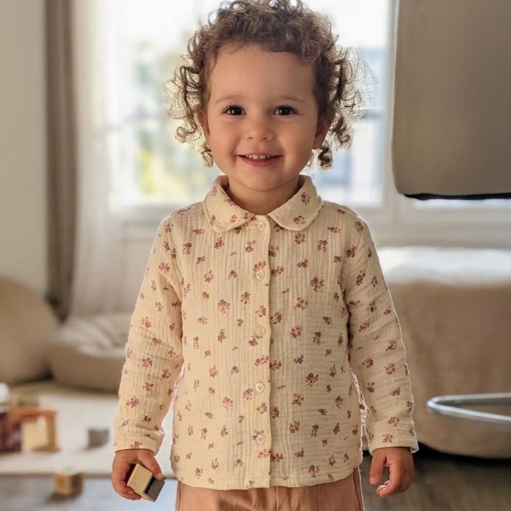 Blouse beige à motifs rouges portée par une petite fille