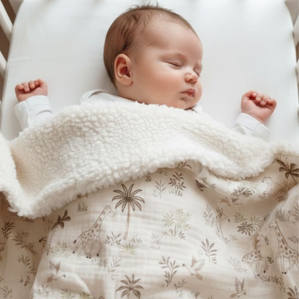 Un bébé recouvert de la couverture safari avec des motifs de safari