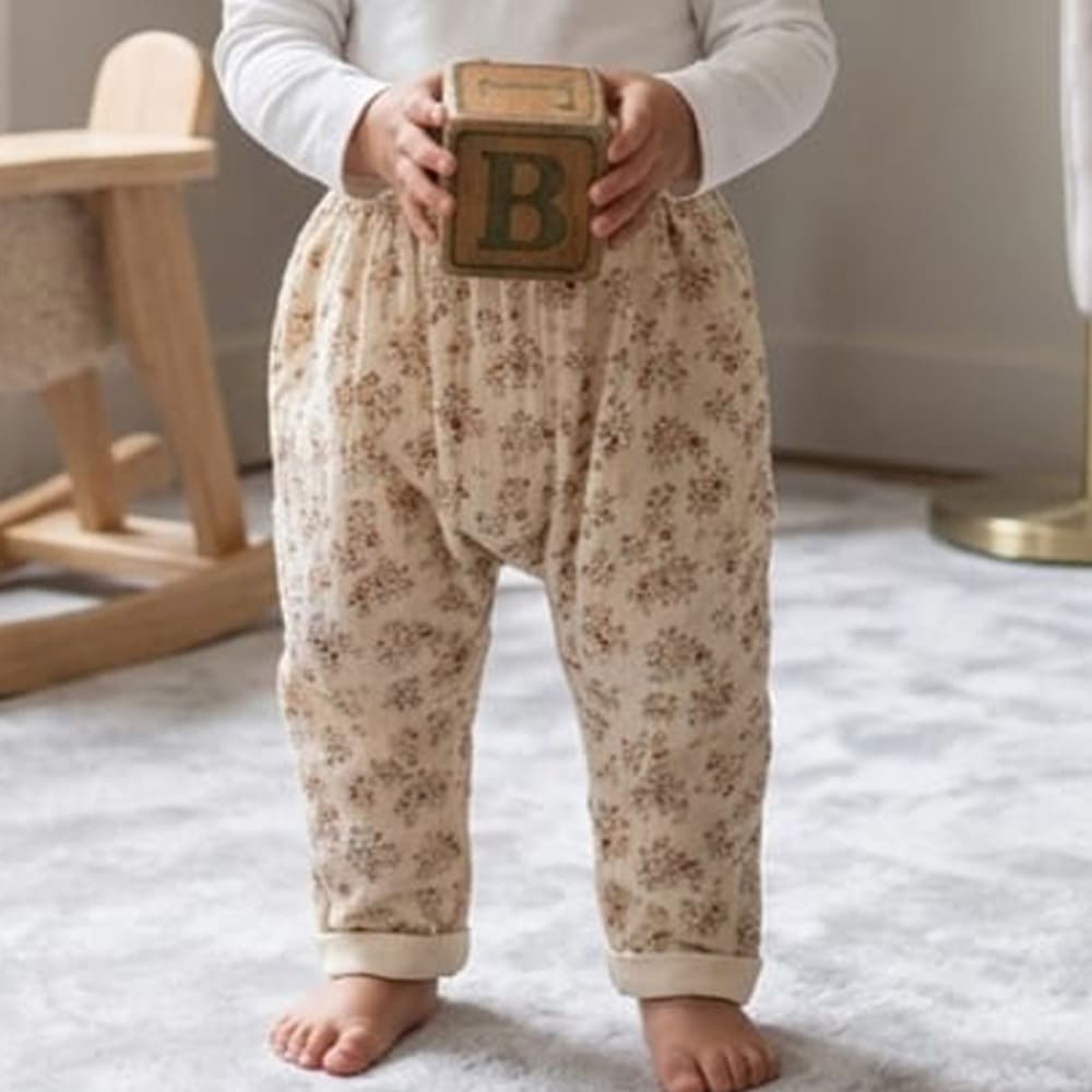 pantalon aby, beige avec des motifs rouges, porté par un enfant