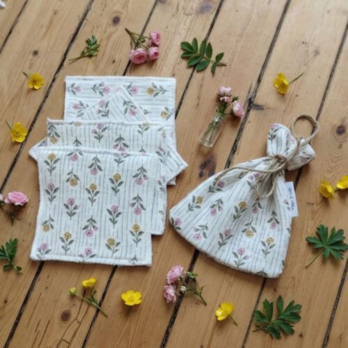 Pochon avec 4 lingettes aux motifs fleuris posé sur une table en bois