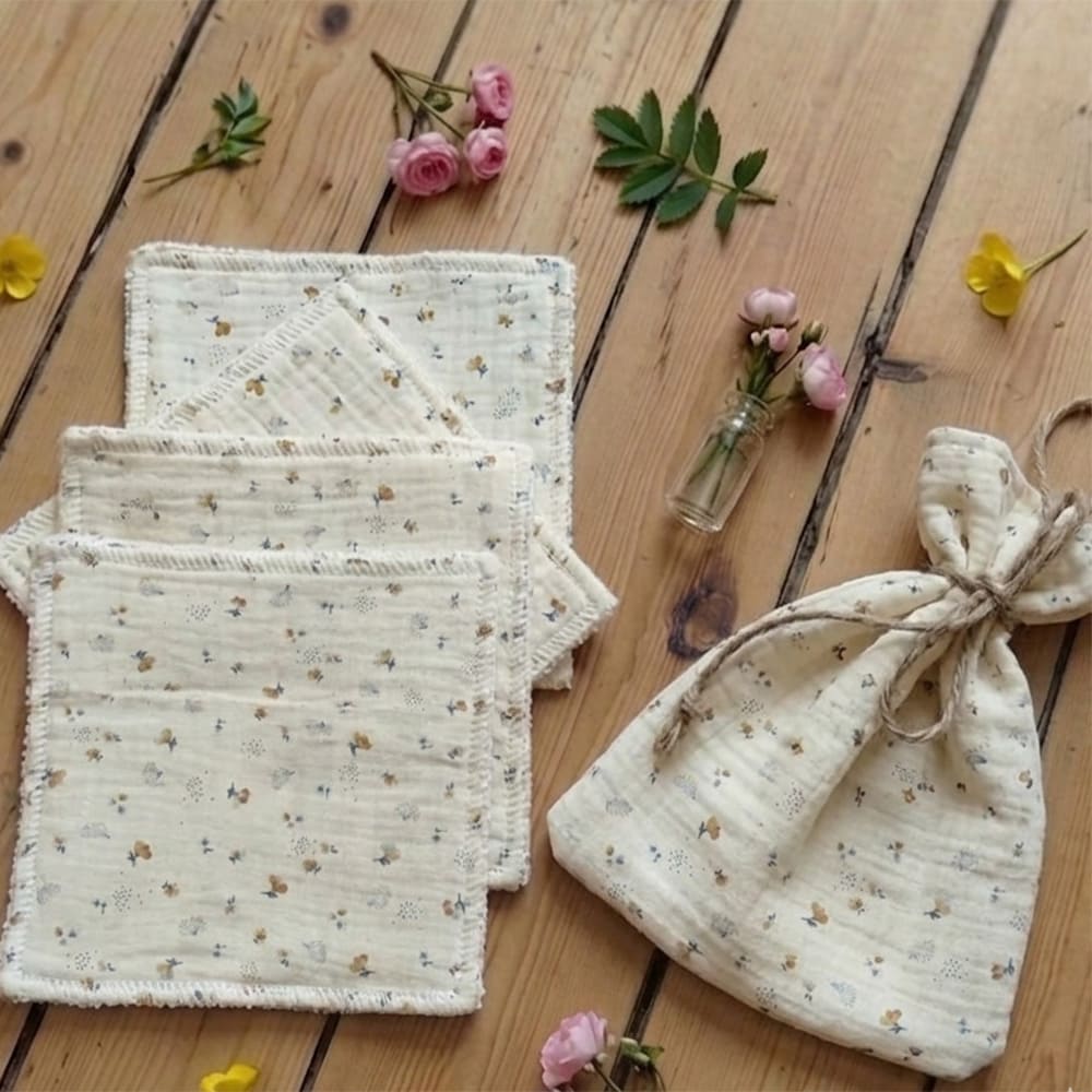 Pochon avec 4 lingettes aux motifs printaniers posé sur une table en bois
