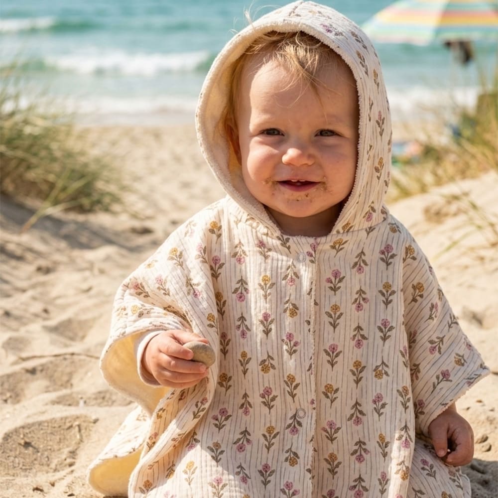 Enfant à la plage dans le poncho de plage Hortense, à motifs fleuris