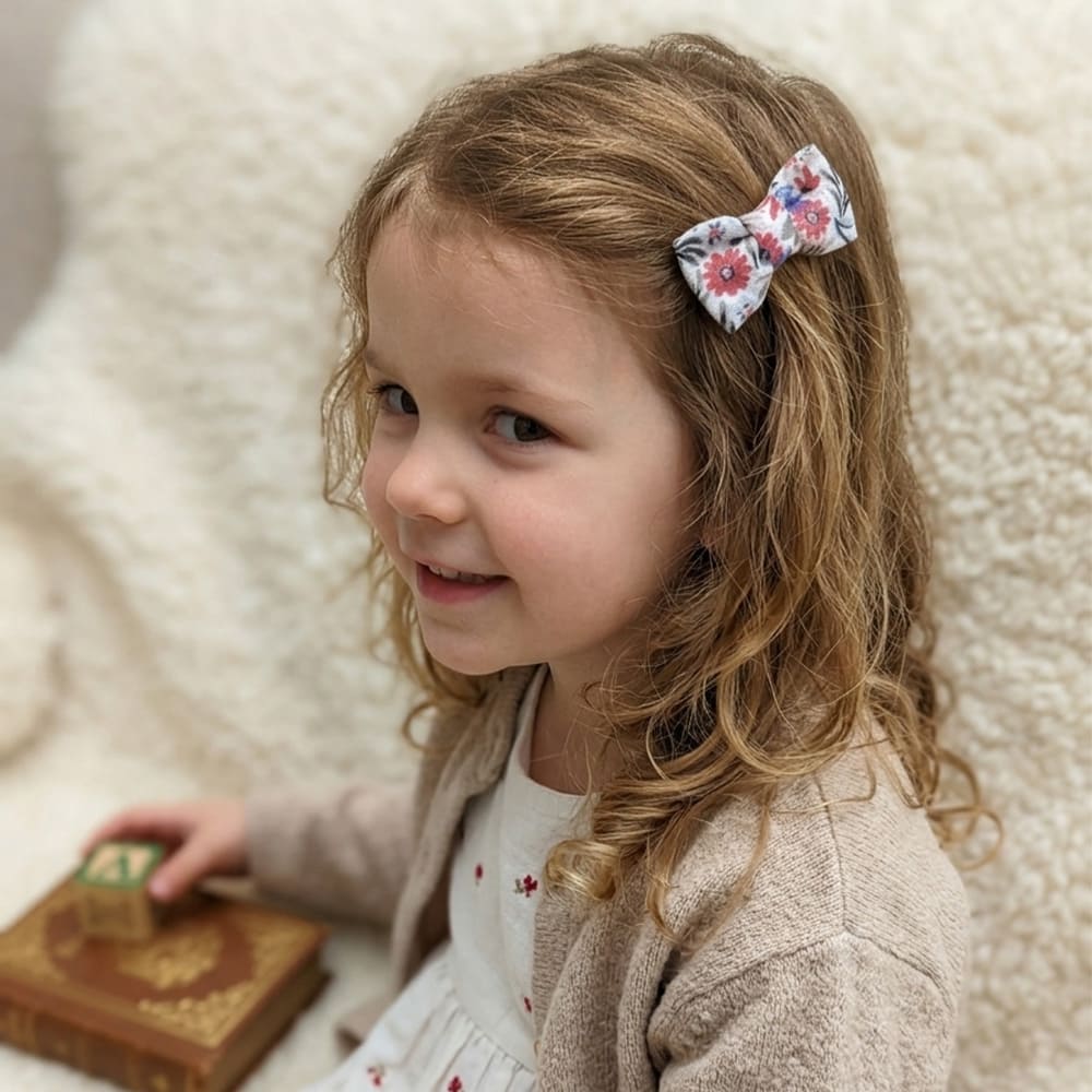 Petite fille avec la barrette Emma dans les cheveux, à motifs bleus et roses