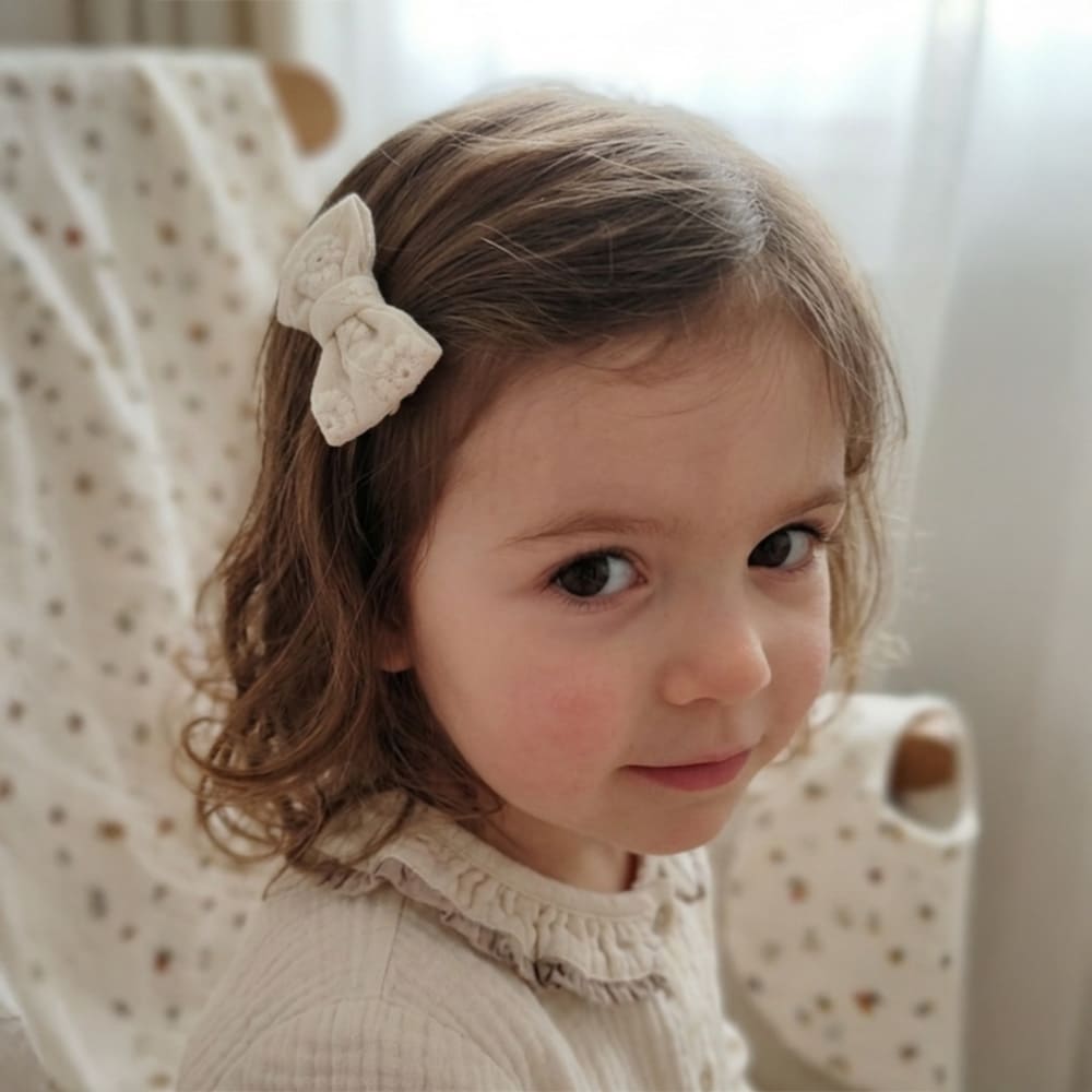 Petite fille avec la barrette Mathilde dans les cheveux, blanches à fleurs blanches brodées