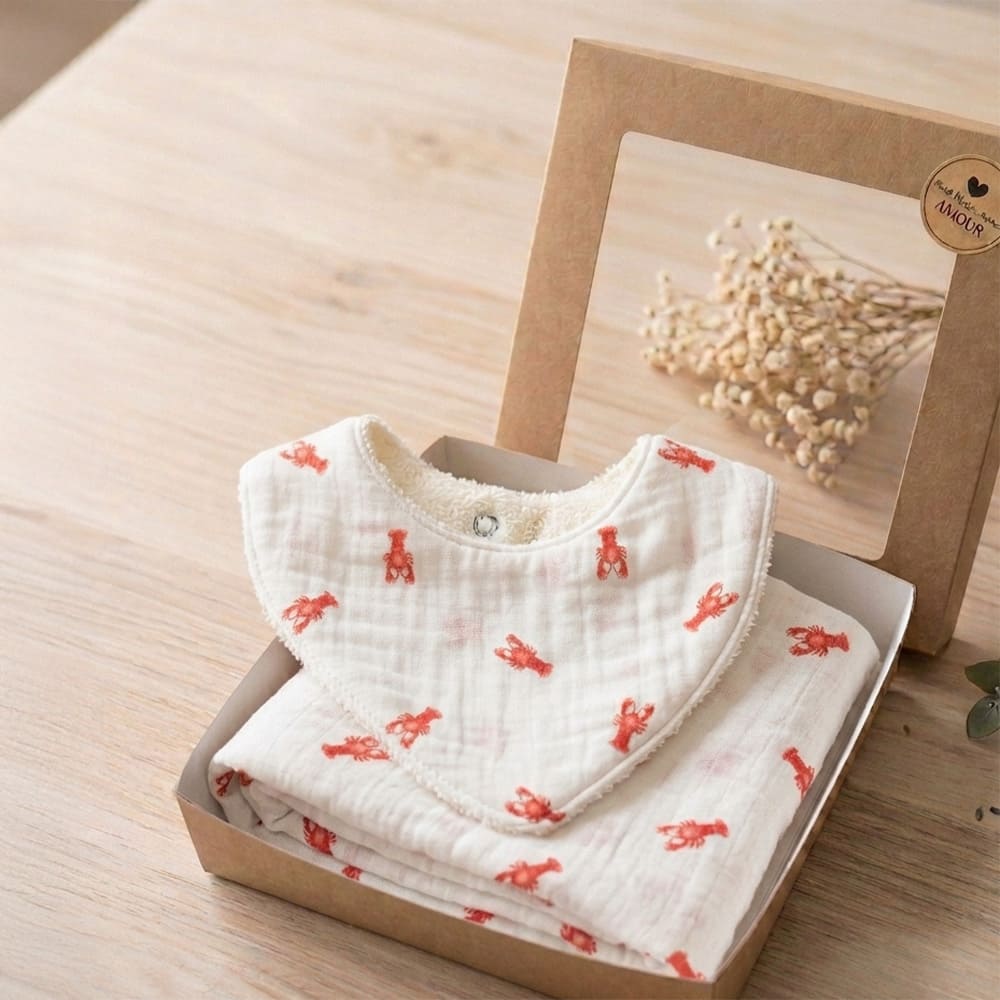Box Petite Citrouille les Petits Homards composé d'un lange et d'un bavoir, blanc avec motifs homards rouges