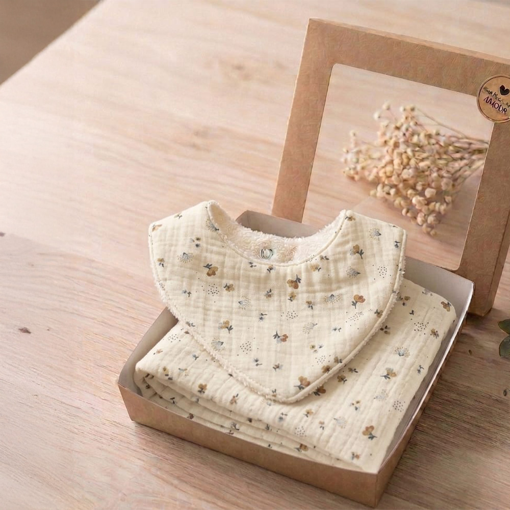 Box Petite Citrouille Lina, composée d'un bavoir et d'un lange aux motifs printaniers
