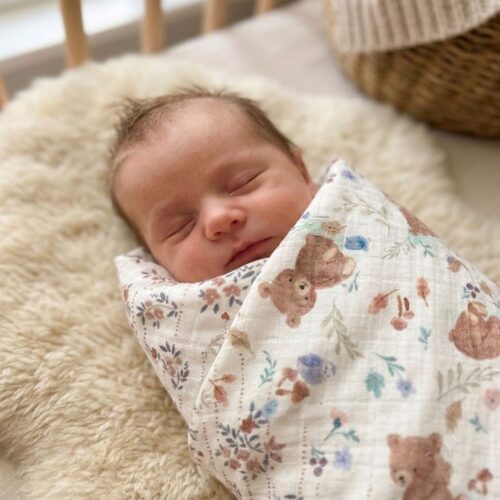 maxi-lange-basile-nounours Bébé emmailloté dans le maxi lange Basile, aux motifs fleuris gris foncé roses et nounours marron