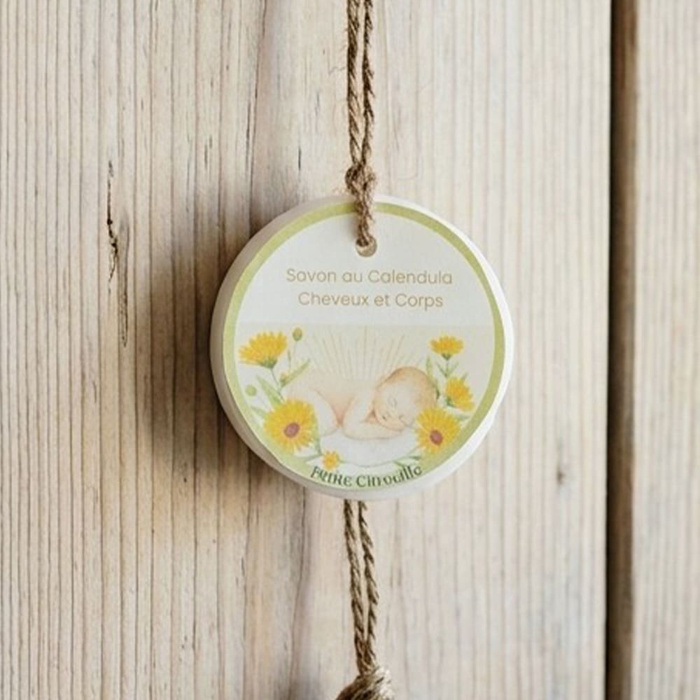 Savon au calendula suspendu devant un fond en bois